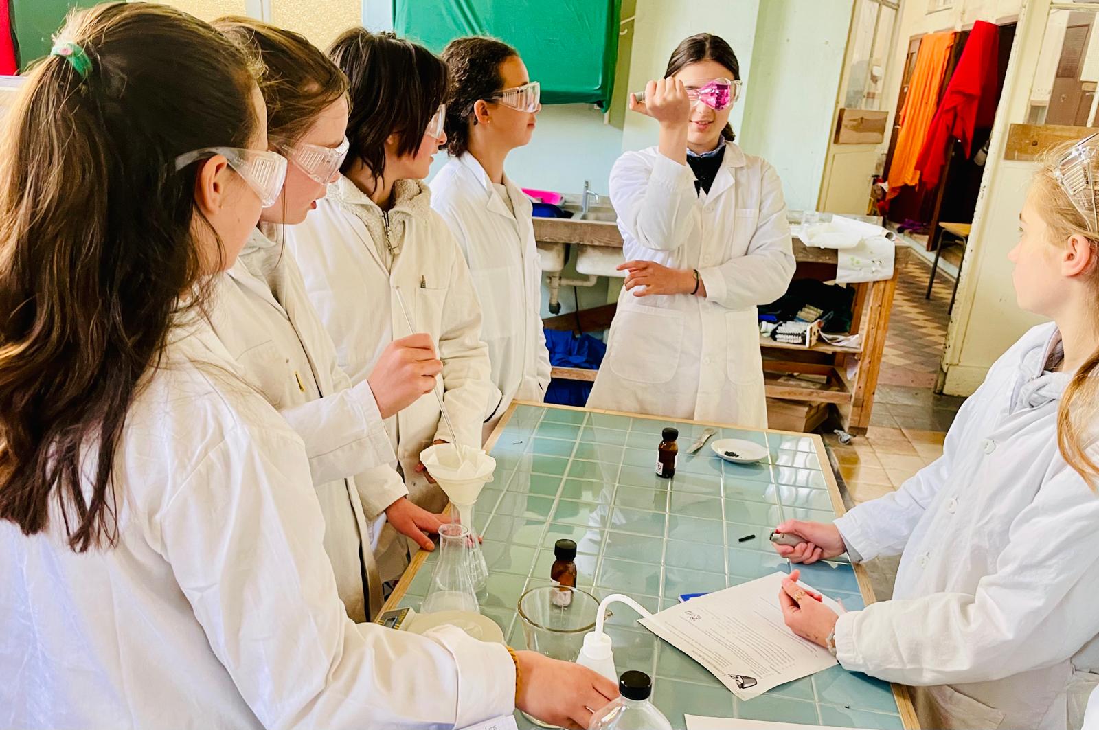 Les élèves en pleine expérience de chimie, en blouse et lunettes